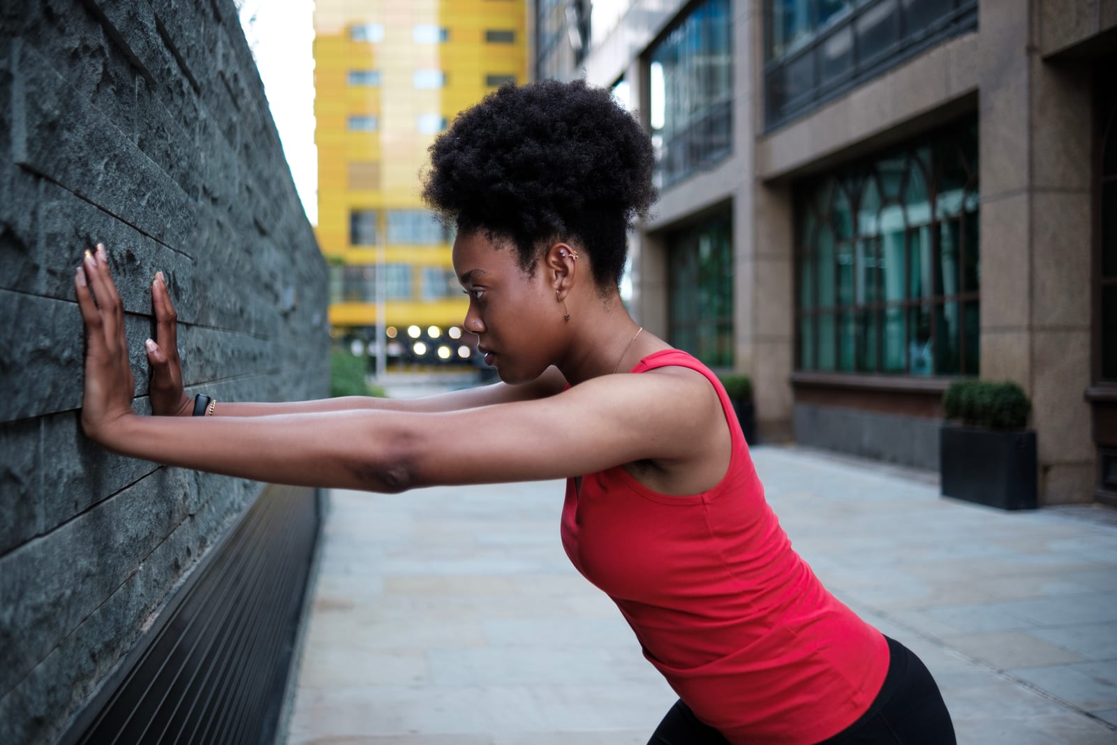 Leaning into a wall with the hands at shoulder height, the setup position for a standing calf stretch
