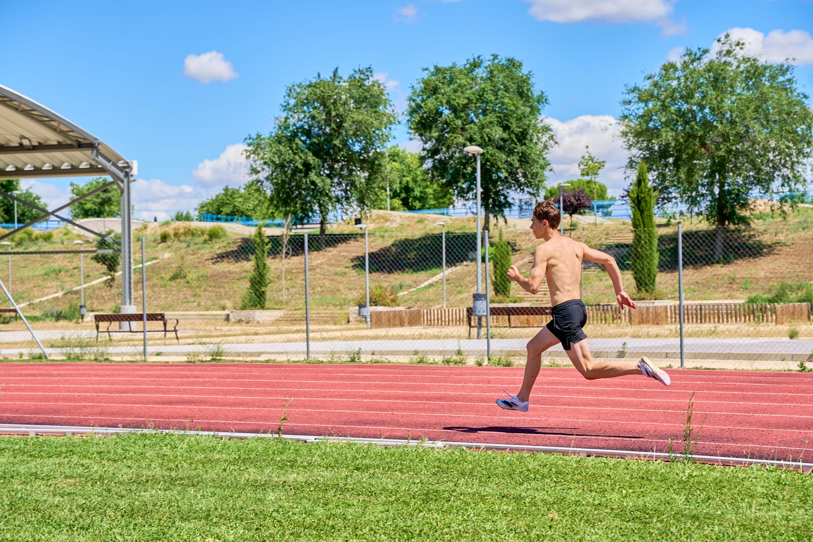 Sprinter at full stride on an outdoor track, the kind of athlete a travelling chiropractor supports