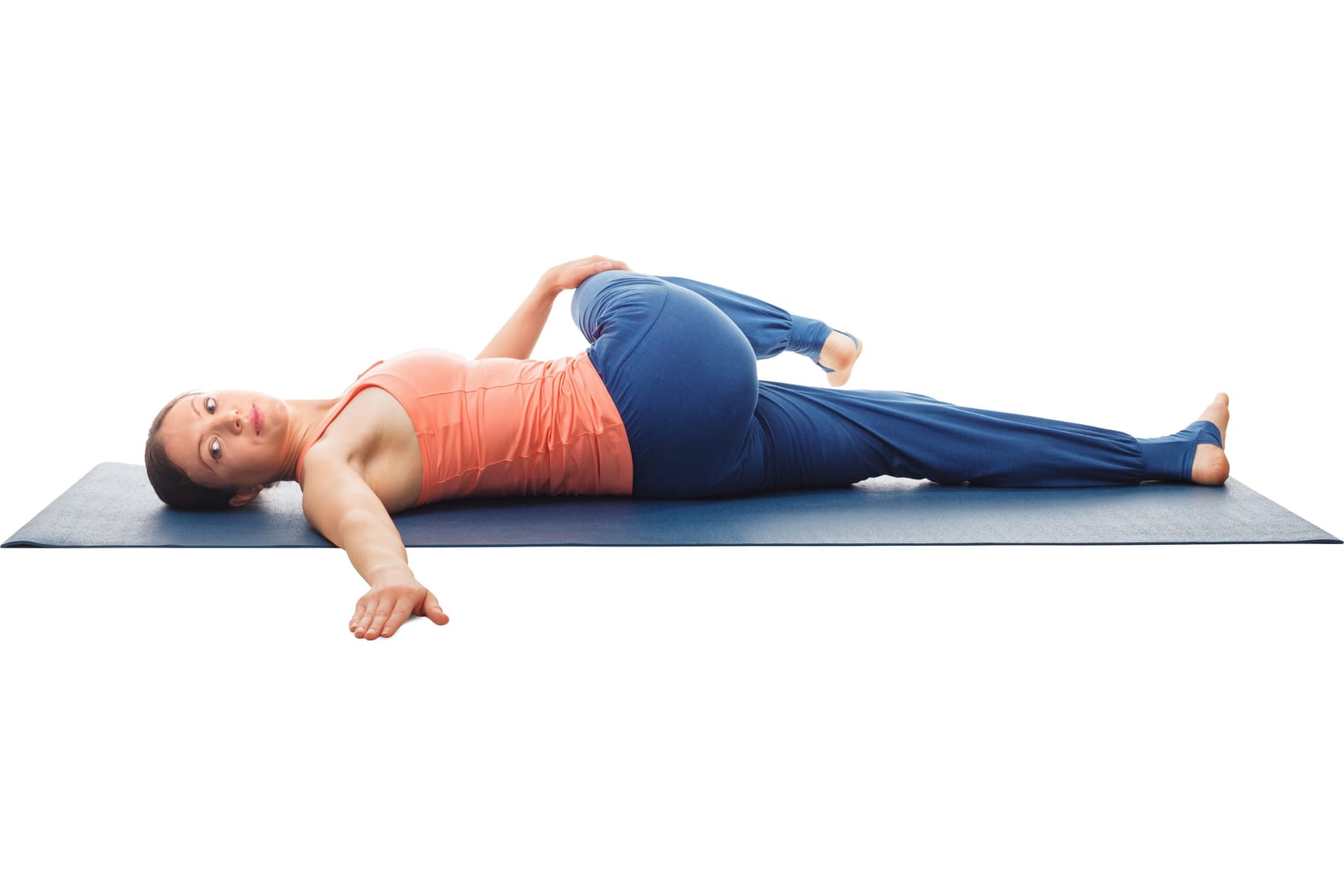 Supine spinal twist on a mat, a gentle way to work the rotation a golf swing depends on