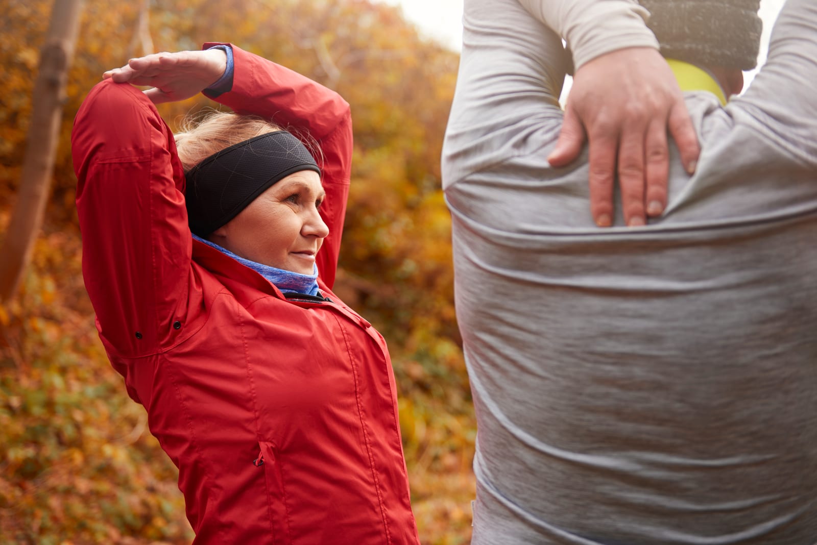 Two older adults stretching outdoors to keep their backs mobile and healthy